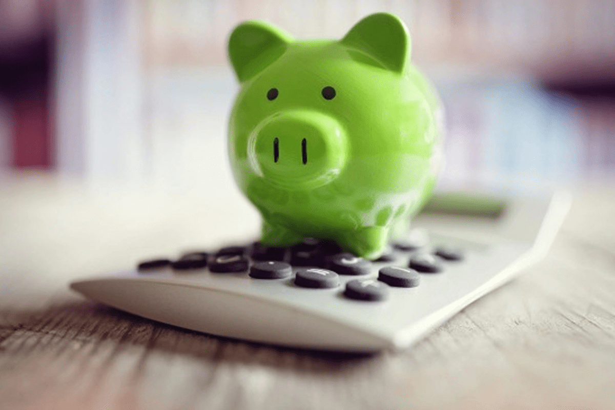 Green piggy bank on a calculator.