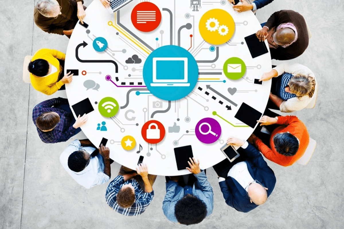 People collaborating around tech-themed round table.