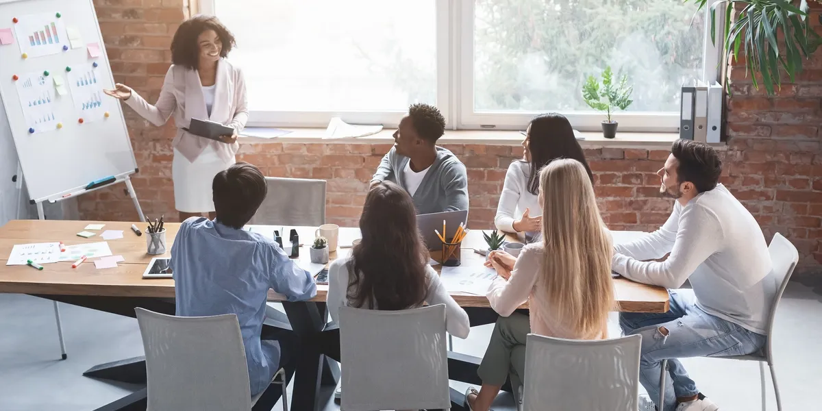 Team meeting with diverse members collaborating around a table.